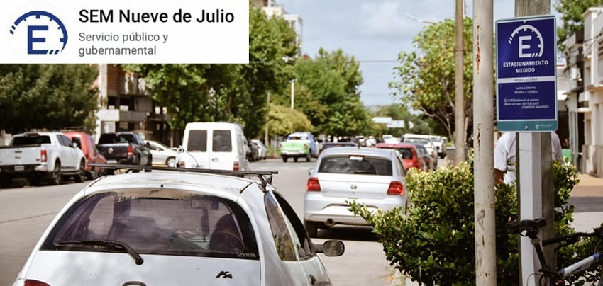 SEM en 9 de Julio está ilustrado con una imagen de una calle del lugar con autos transitando, con un cartel de estacionamiento medido y el logo de la aplicación en dicha localidad.