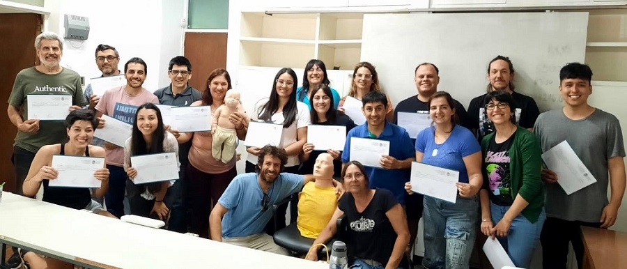 Todos los participantes de la jornada de capacitación sobre conocimientos en maniobras para la Reanimación Cardiopulmonar (RCP) posan juntos en el aula mostrando sus certificaciones